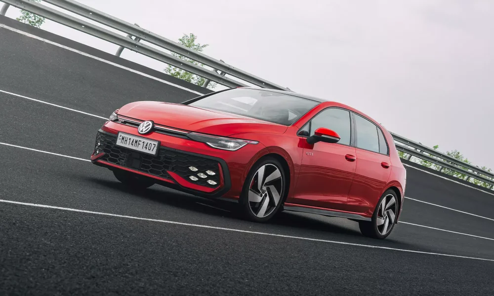 Red Volkswagen Golf GTI side view on road